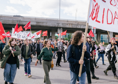 Drapeau rouge communiste flotte devant une masse de manifestant